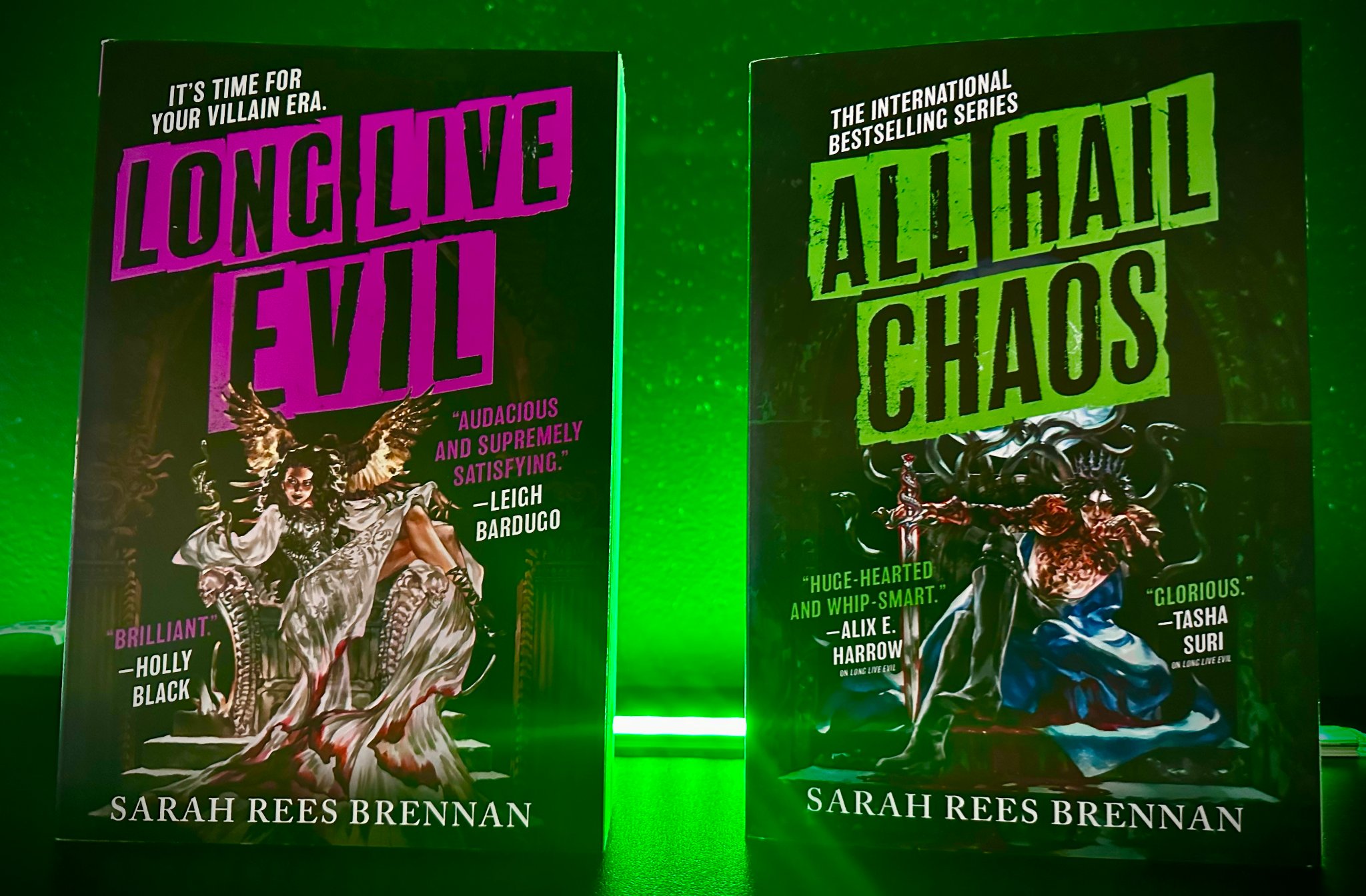 Long Live Evil and All Hail Chaos by Sarah Rees Brennan displayed under dramatic green lighting